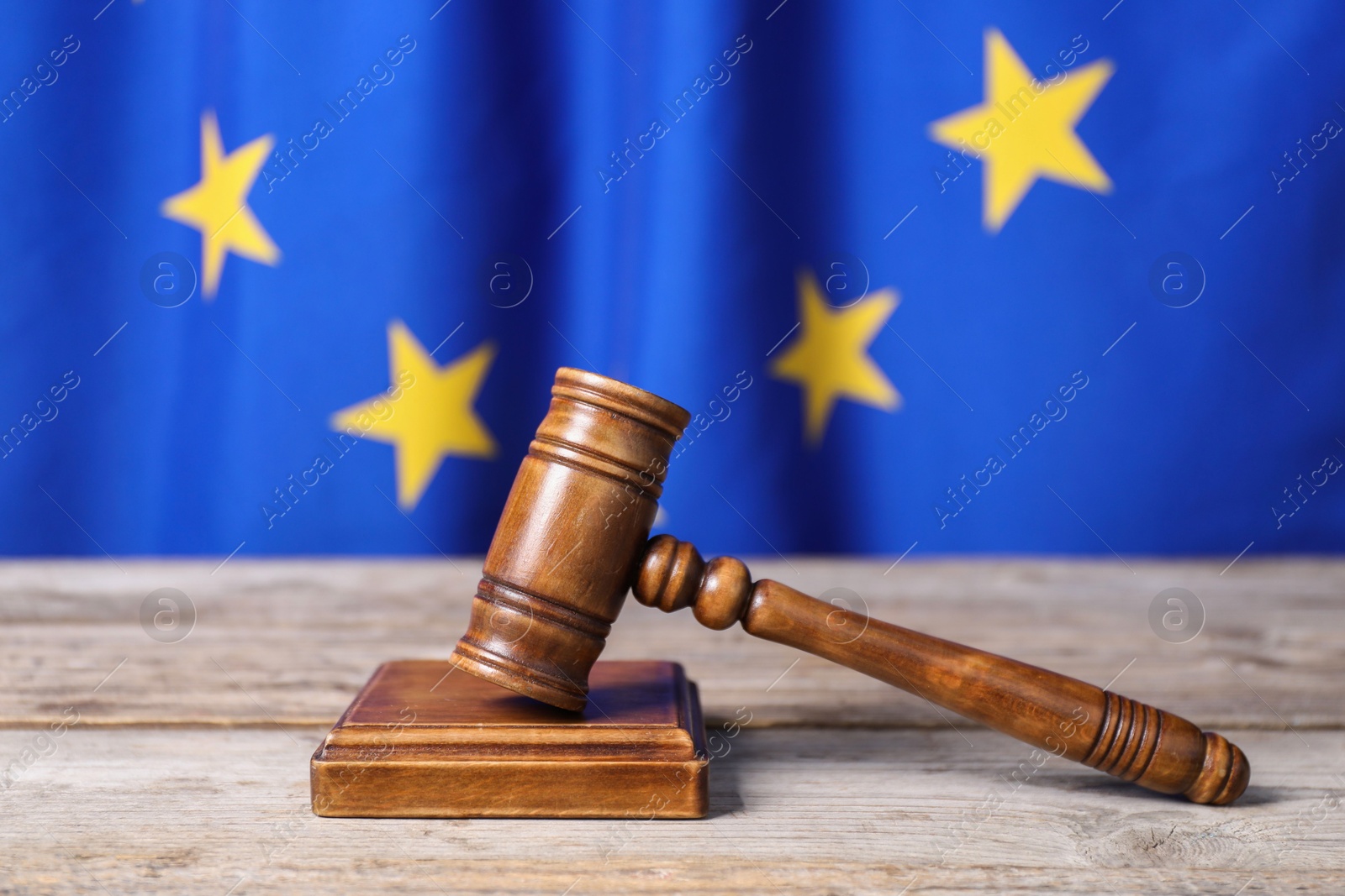 Photo of Judge's gavel on wooden table against European Union flag