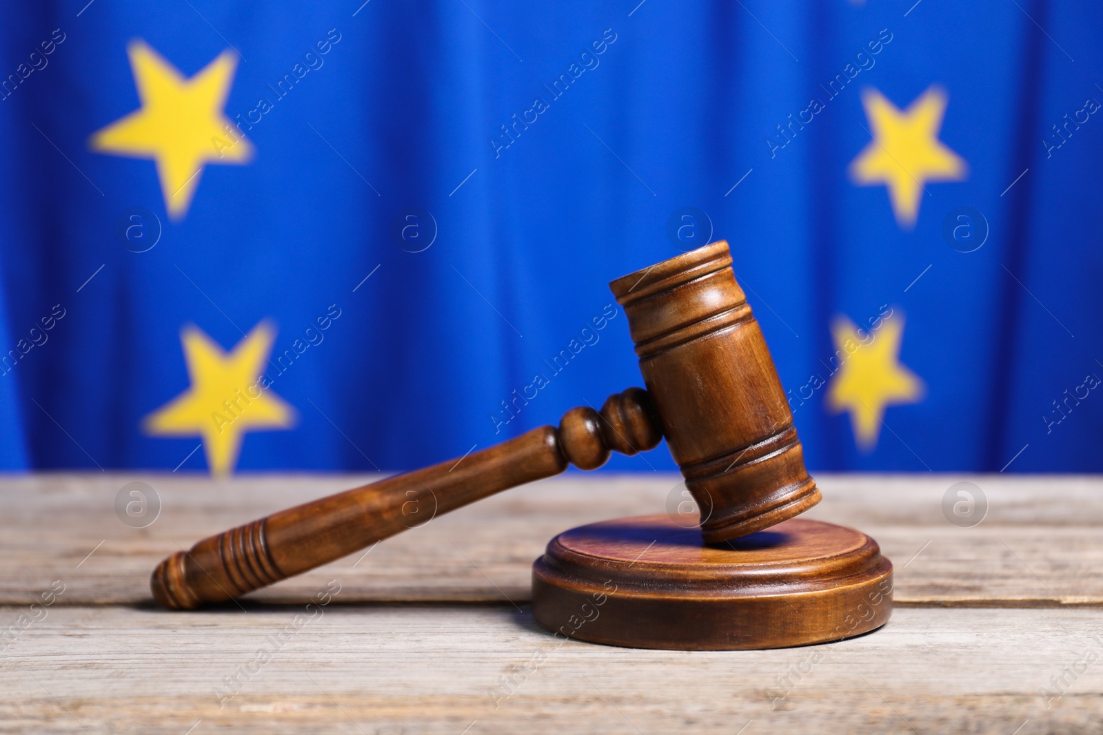 Photo of Judge's gavel on wooden table against European Union flag