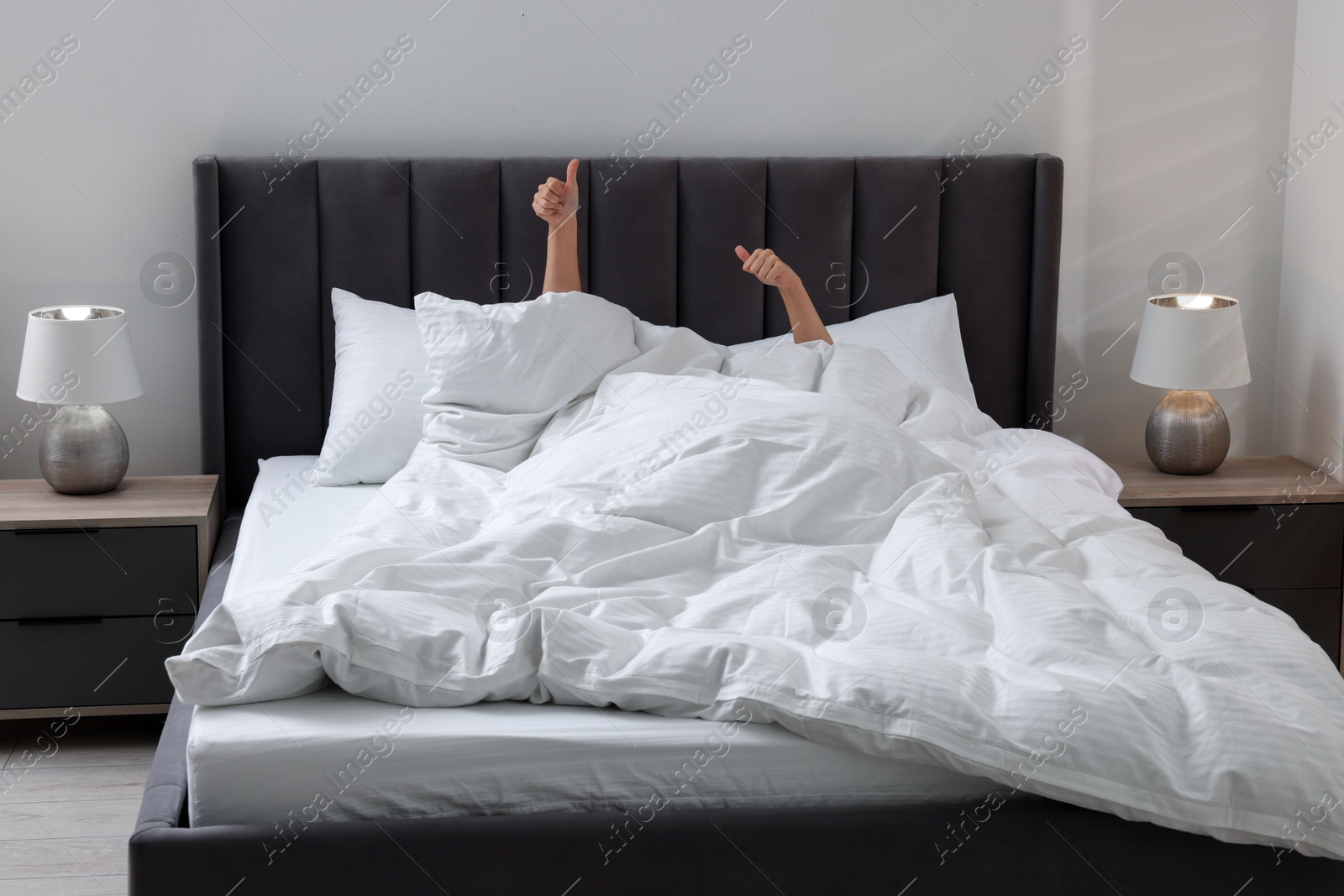 Photo of Woman awaking in comfortable bed with beautiful linens at home