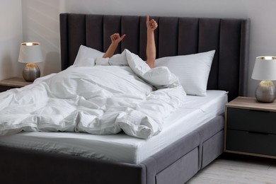 Photo of Woman awaking in comfortable bed with beautiful linens at home