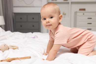 Photo of Cute little baby with rattles on bed indoors, space for text