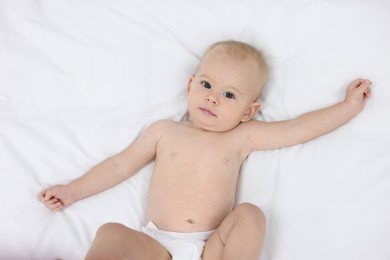 Photo of Cute little baby on bed indoors, top view