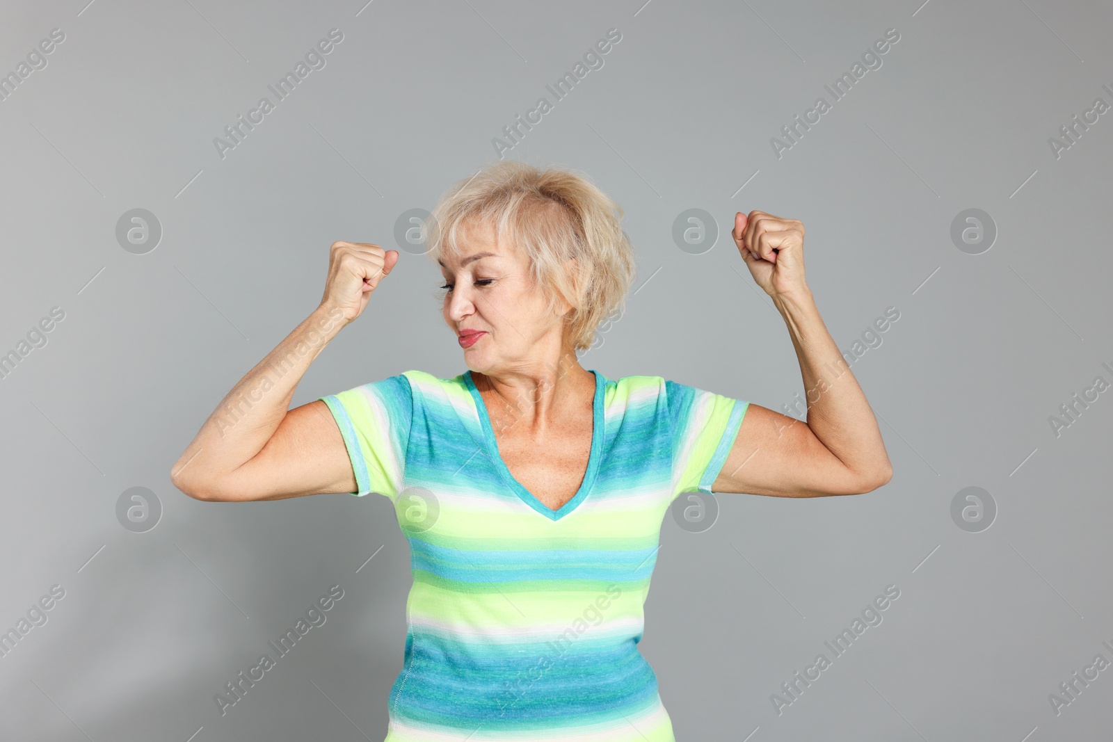 Photo of Senior woman exercising on light grey background