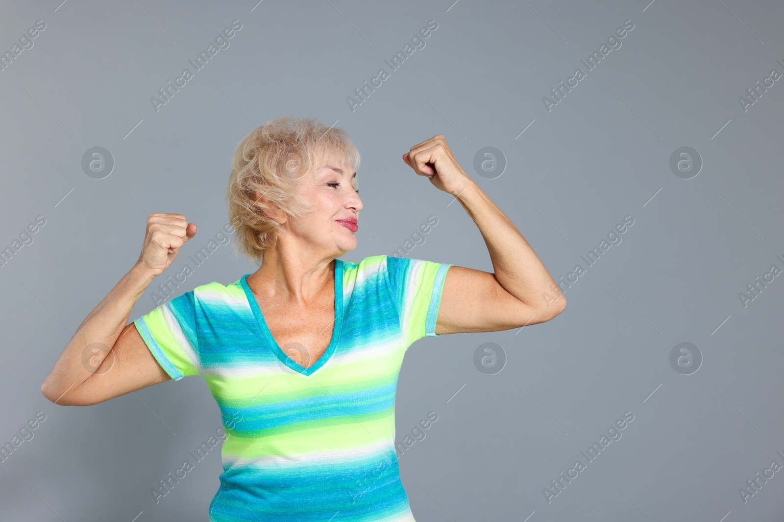 Photo of Senior woman exercising on light grey background. Space for text