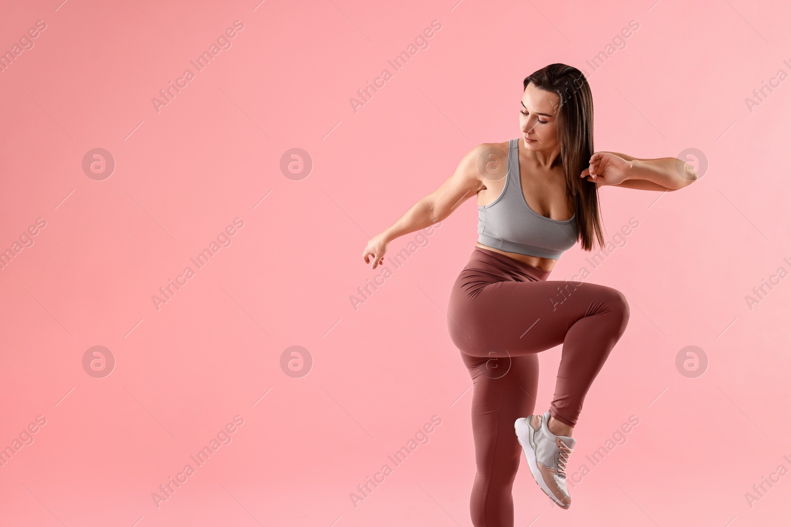 Photo of Woman in gym clothes doing exercise on pink background, space for text