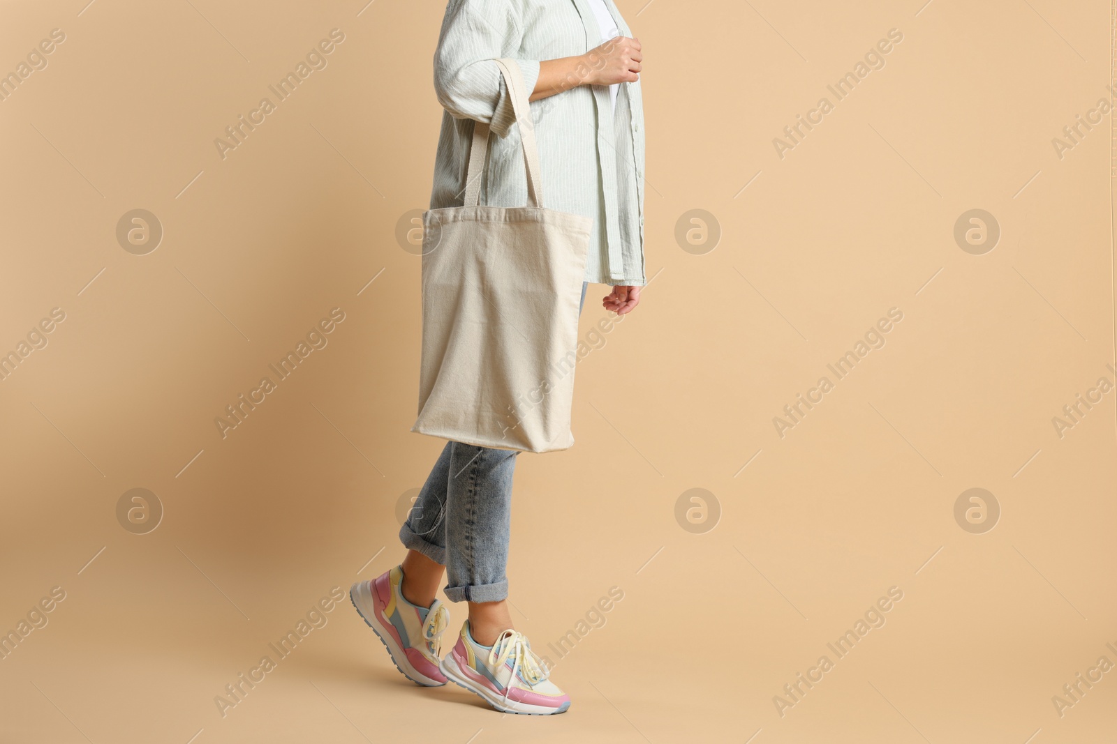 Photo of Woman with blank shopper bag on color background, closeup. Mockup for design