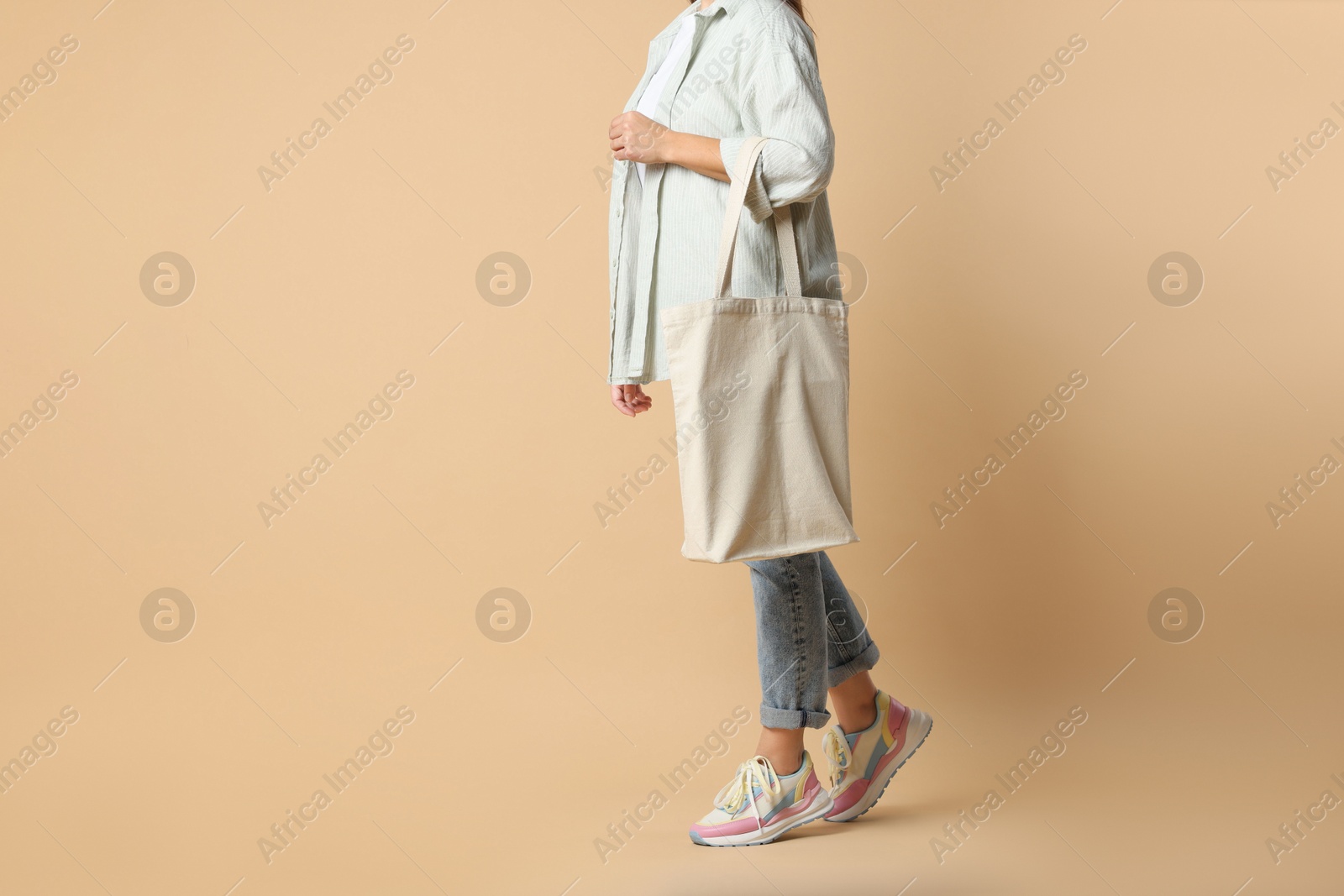 Photo of Woman with blank shopper bag on color background, closeup. Mockup for design