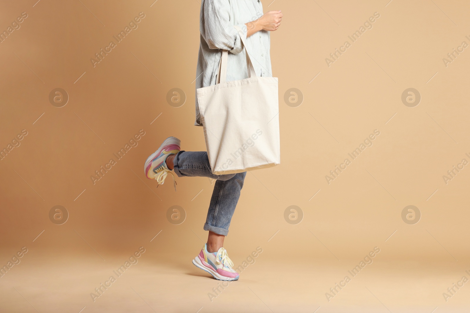 Photo of Woman with blank shopper bag on color background, closeup. Mockup for design