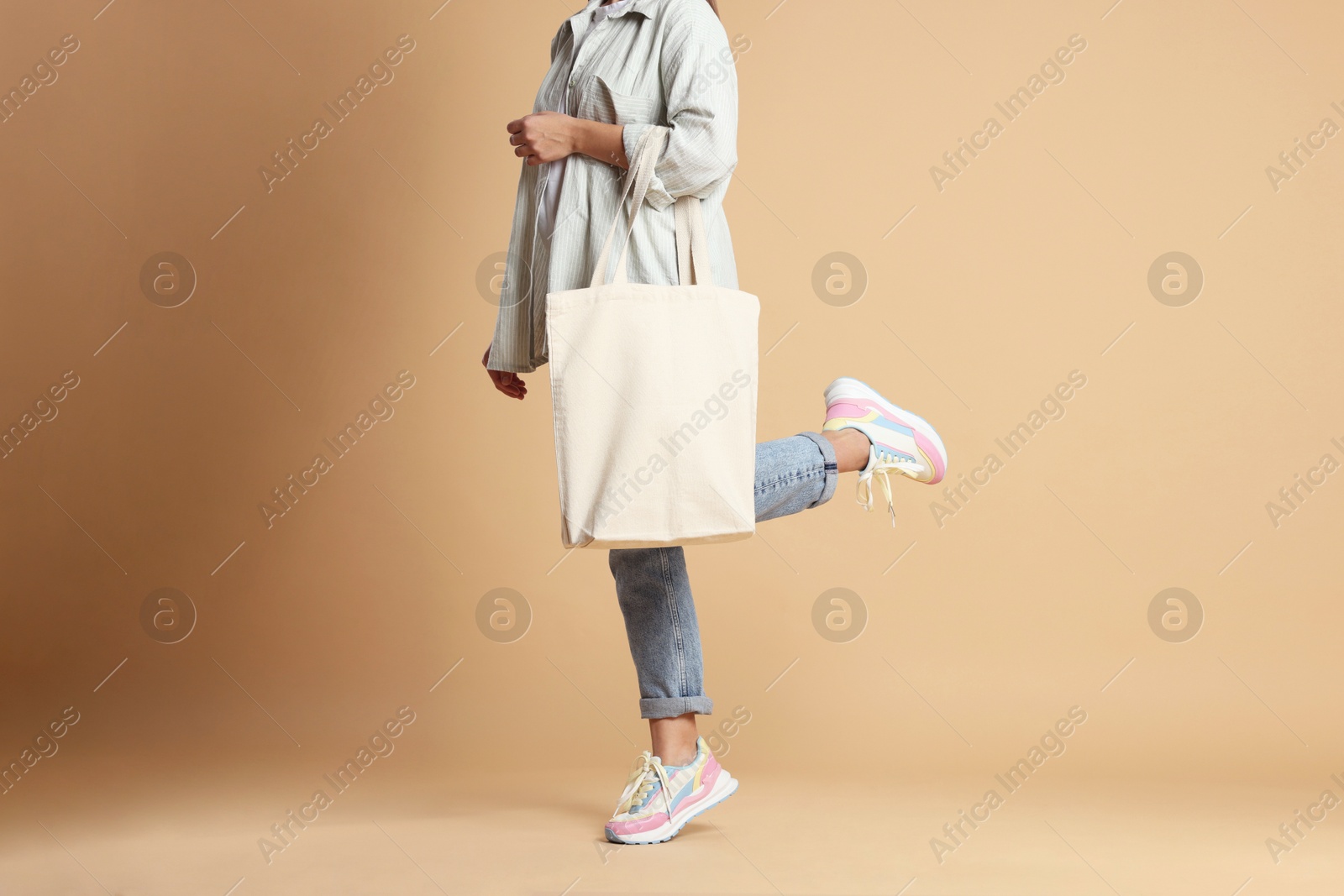 Photo of Woman with blank shopper bag on color background, closeup. Mockup for design