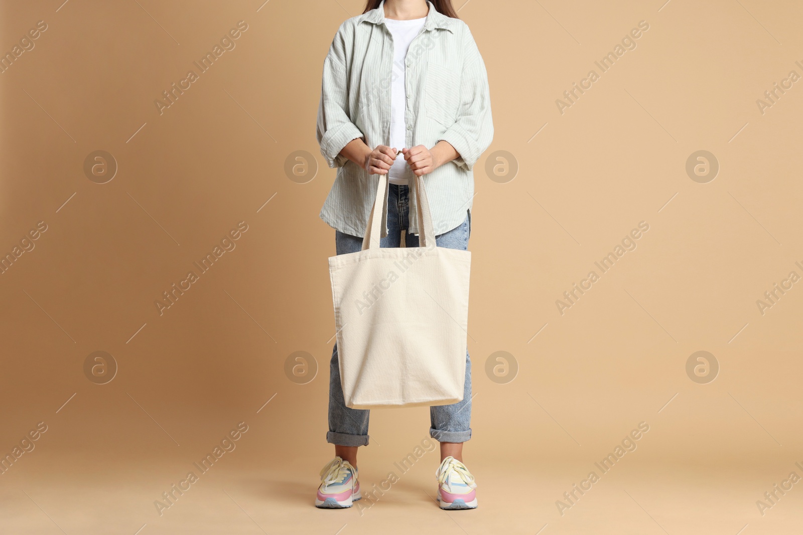 Photo of Woman with blank shopper bag on color background, closeup. Mockup for design