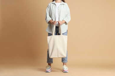 Photo of Woman with blank shopper bag on color background, closeup. Mockup for design