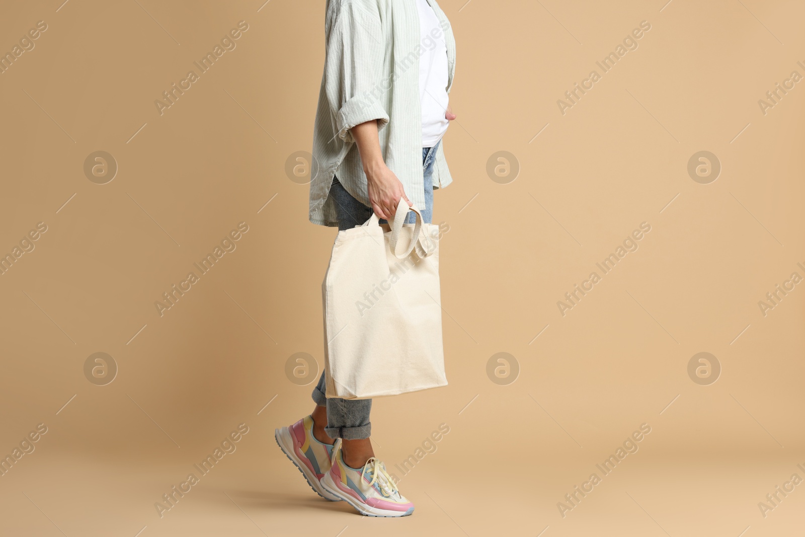 Photo of Woman with blank shopper bag on color background, closeup. Mockup for design