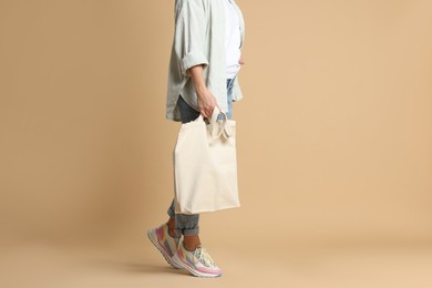 Photo of Woman with blank shopper bag on color background, closeup. Mockup for design