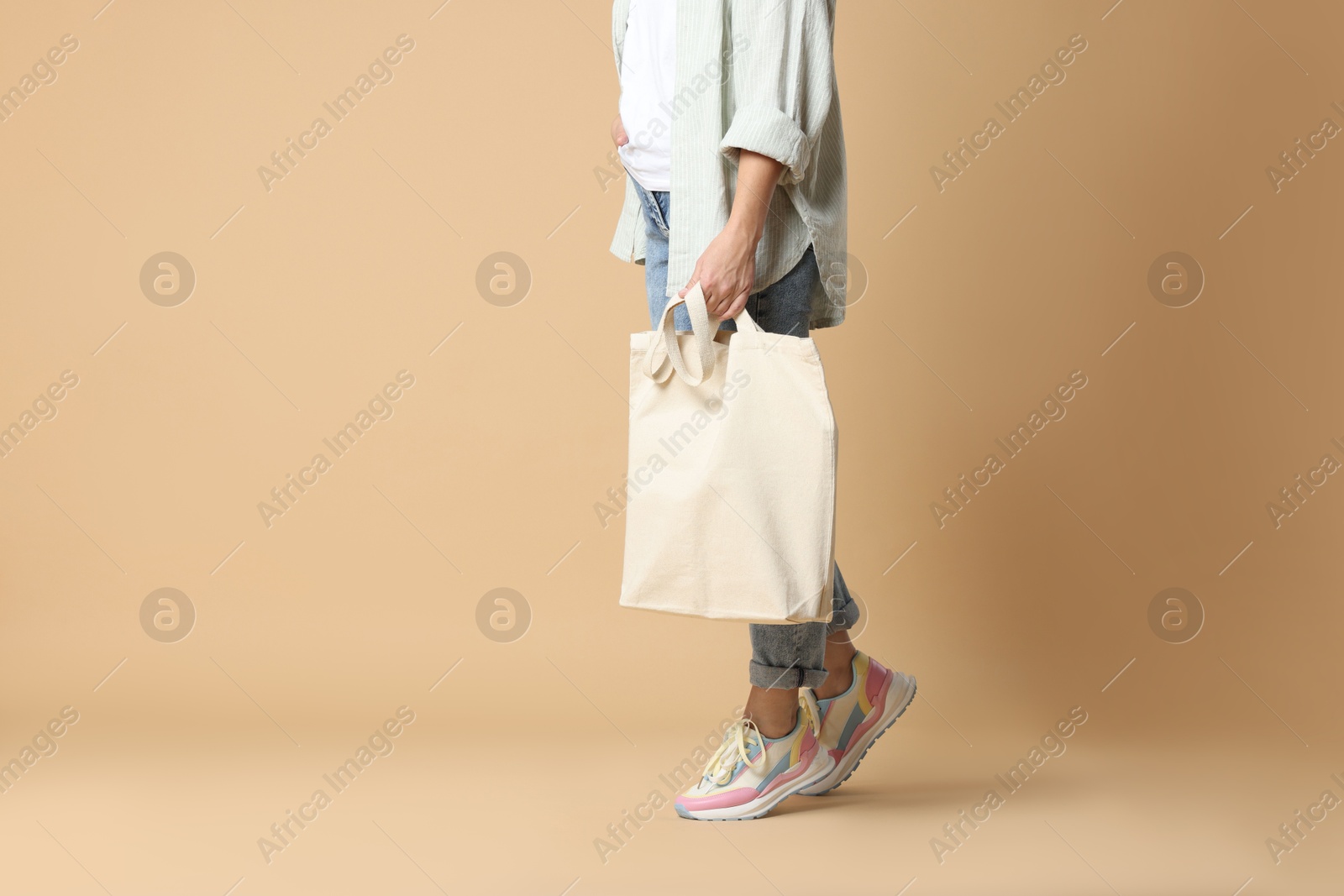 Photo of Woman with blank shopper bag on color background, closeup. Mockup for design