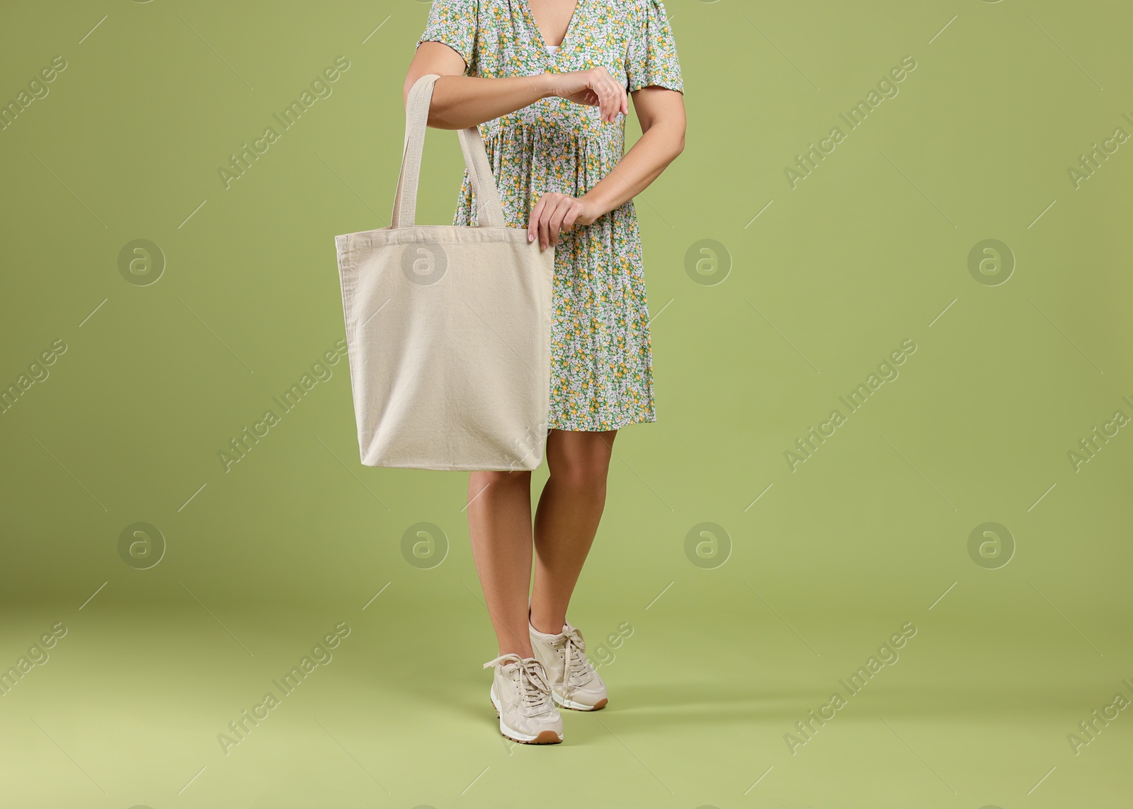 Photo of Woman with blank shopper bag on color background, closeup. Mockup for design