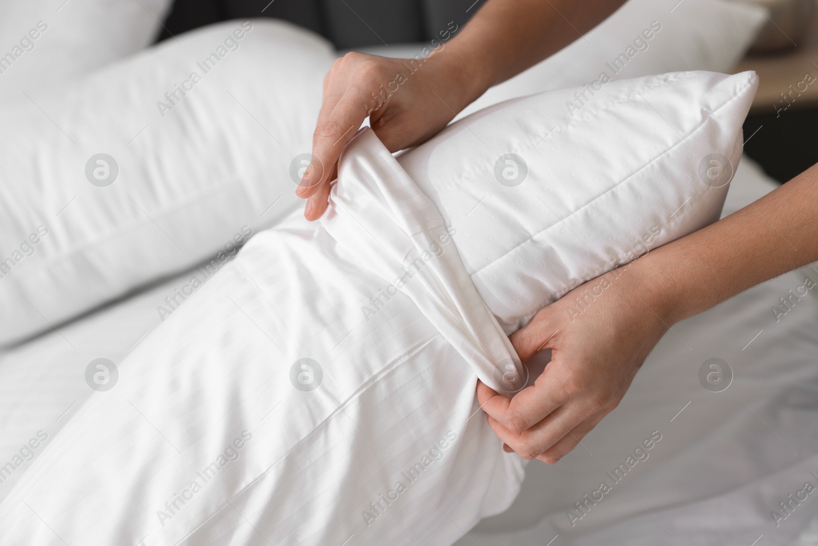 Photo of Woman changing clean bed linens at home, closeup