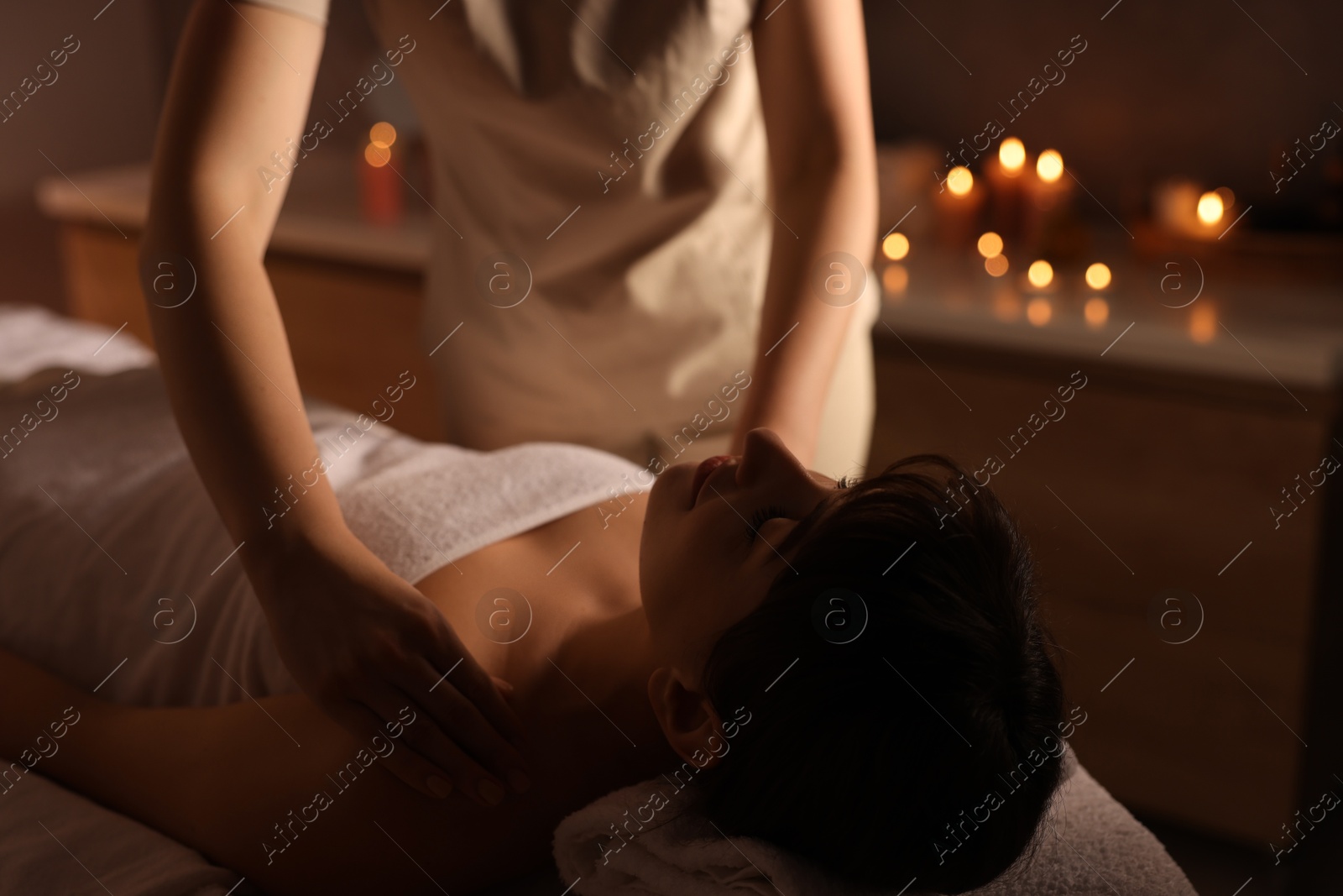 Photo of Young woman receiving massage in spa salon