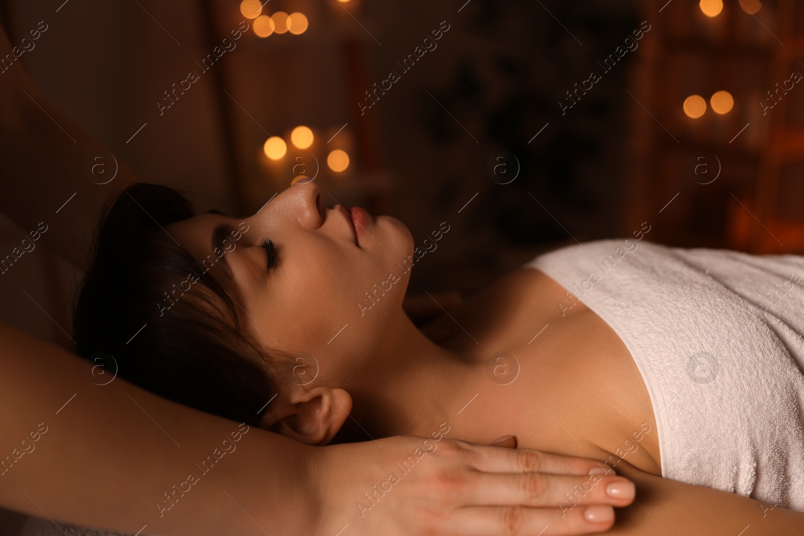 Photo of Young woman receiving massage in spa salon