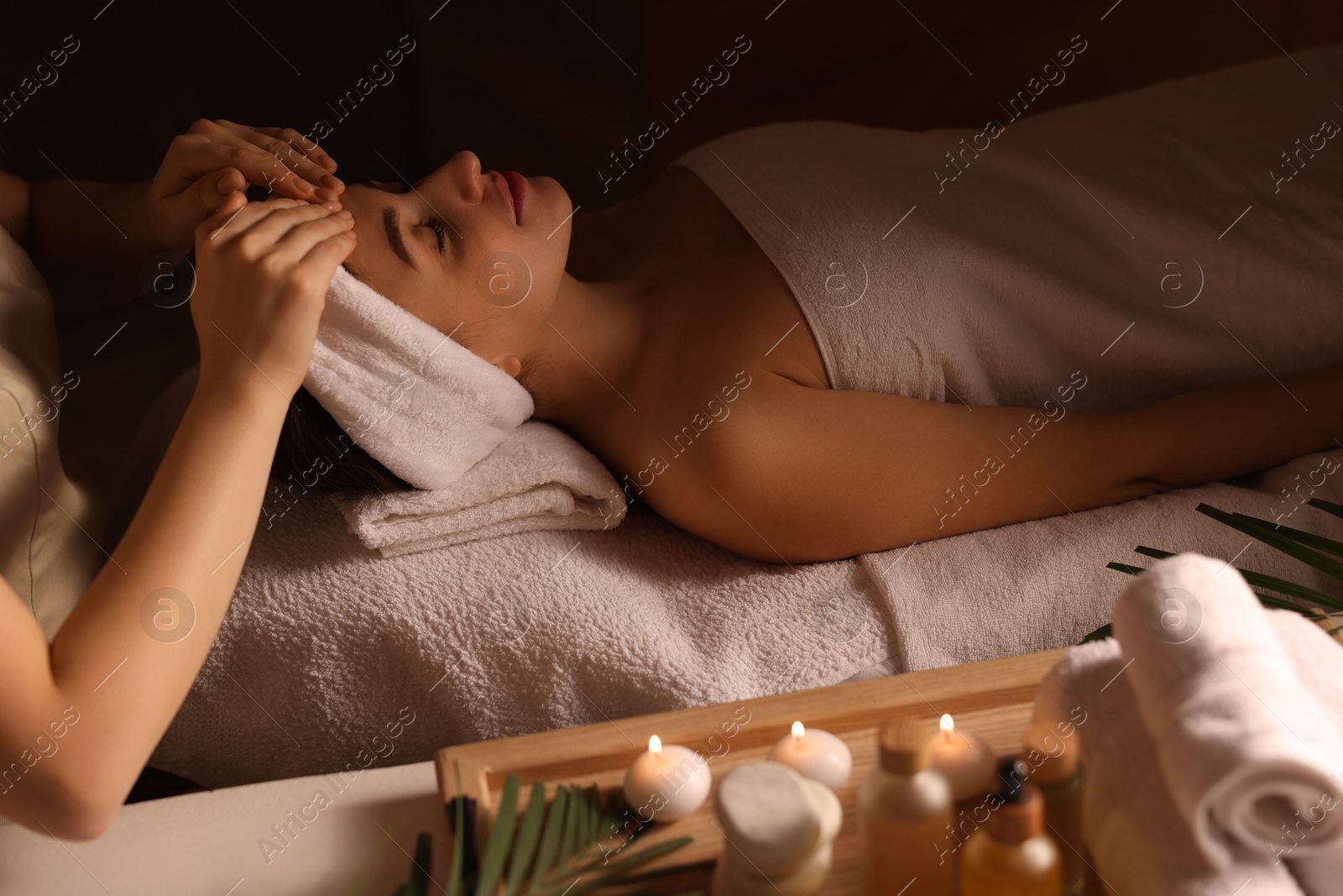 Photo of Young woman receiving massage in spa salon