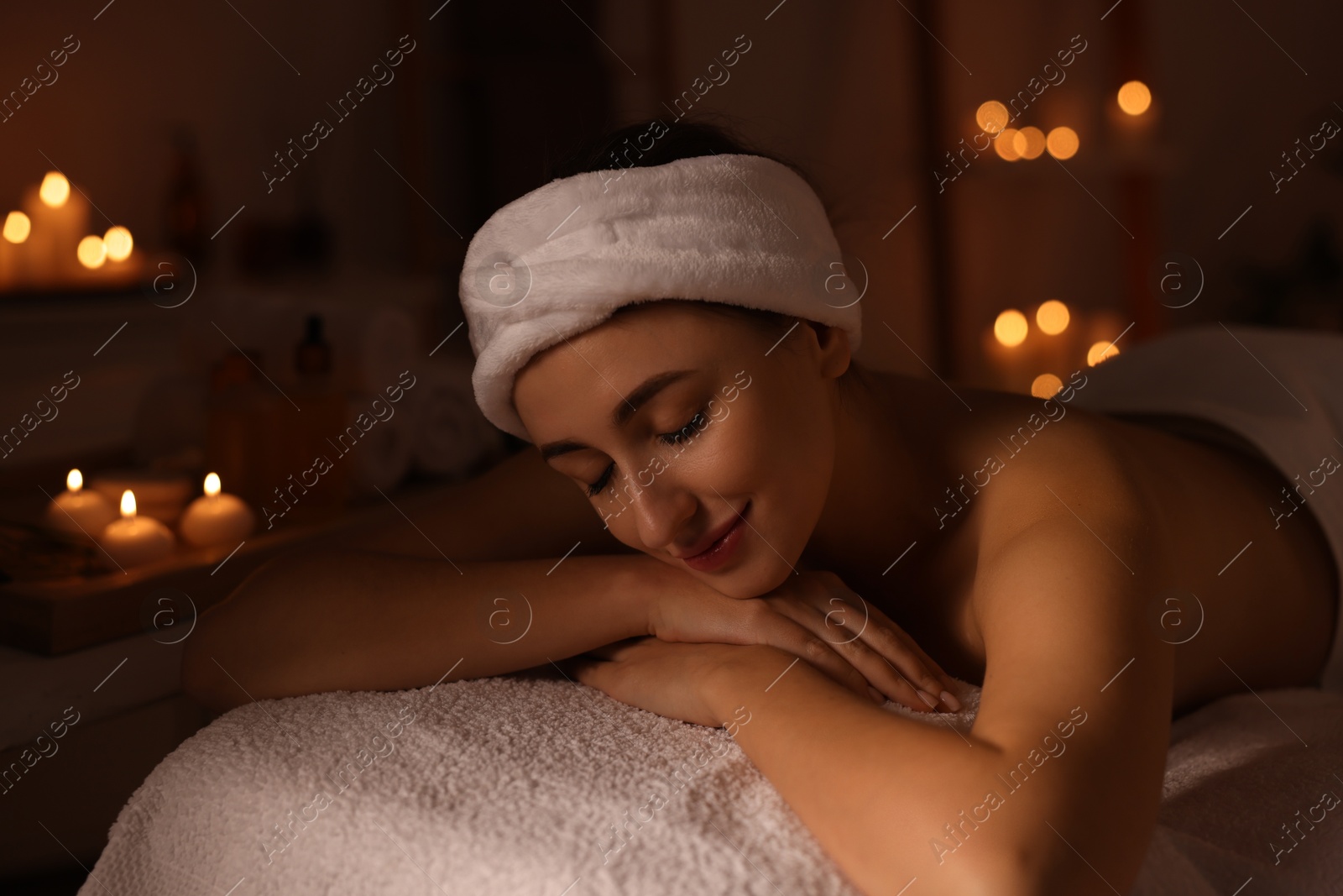 Photo of Young woman relaxing after massage in spa salon