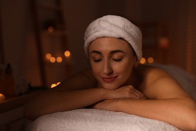 Photo of Young woman relaxing after massage in spa salon