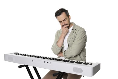 Photo of Thoughtful man sitting near synthesizer on white background