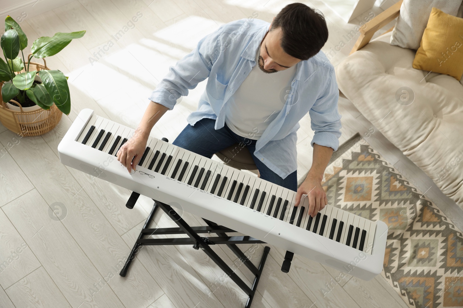 Photo of Man playing synthesizer at home, above view