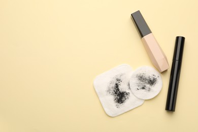 Photo of Dirty cotton pads and makeup products on beige background, flat lay. Space for text