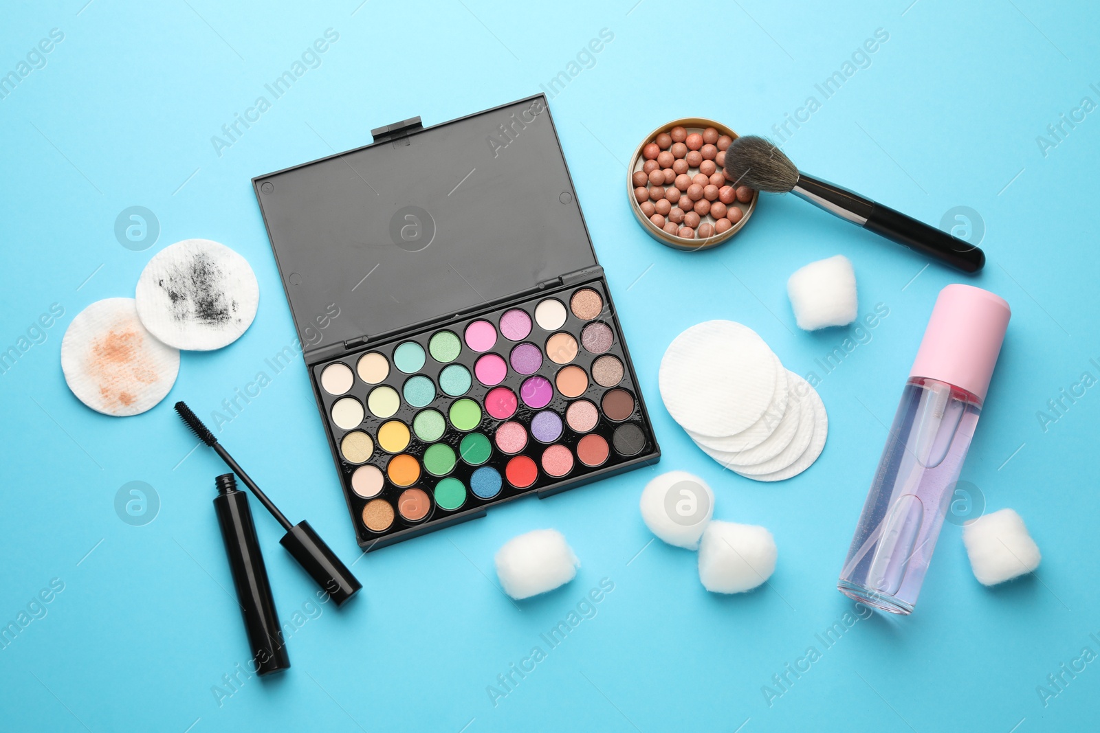 Photo of Flat lay composition with cotton pads and makeup products on light blue background