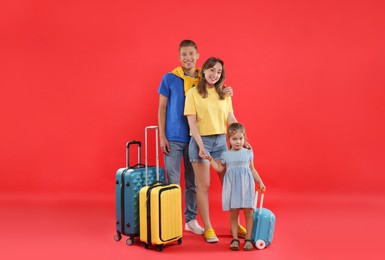 Photo of Travellers with suitcases and backpack. Happy family on red background