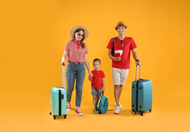 Photo of Travellers with suitcases and backpack. Happy family on yellow background