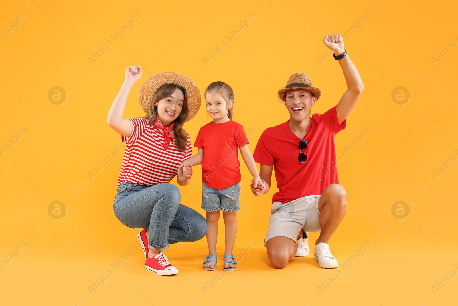 Photo of Happy young woman, man and cute little girl on yellow background