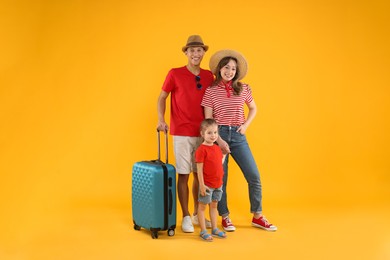 Photo of Travellers with suitcase. Happy family on yellow background