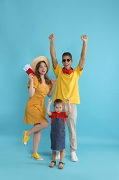 Photo of Travellers with passport and tickets. Happy family on light blue background