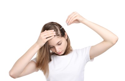 Photo of Hair loss problem. Girl applying serum onto hairline on white background