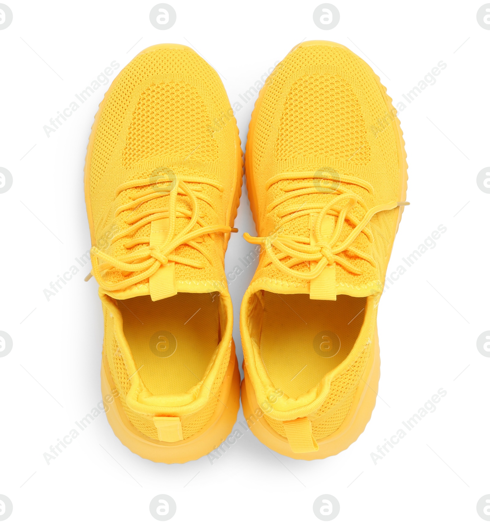 Photo of Pair of stylish yellow sneakers isolated on white, top view