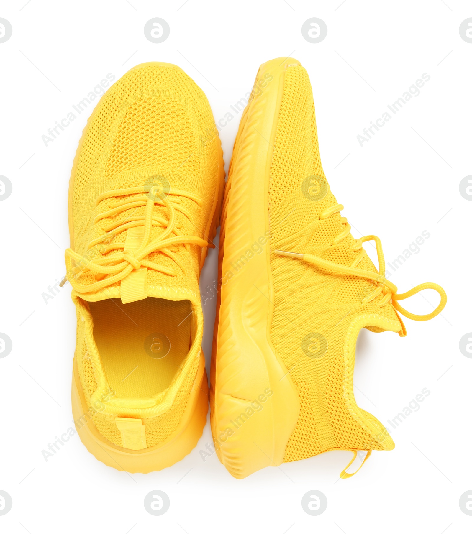 Photo of Pair of stylish yellow sneakers isolated on white, top view