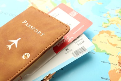 Photo of Passport with tickets on world map, closeup