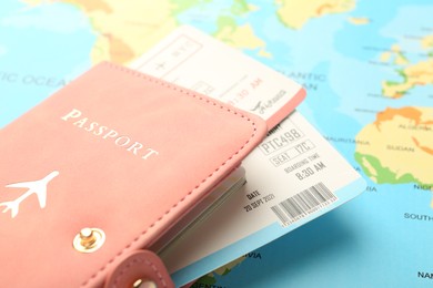 Photo of Passport with tickets on world map, closeup