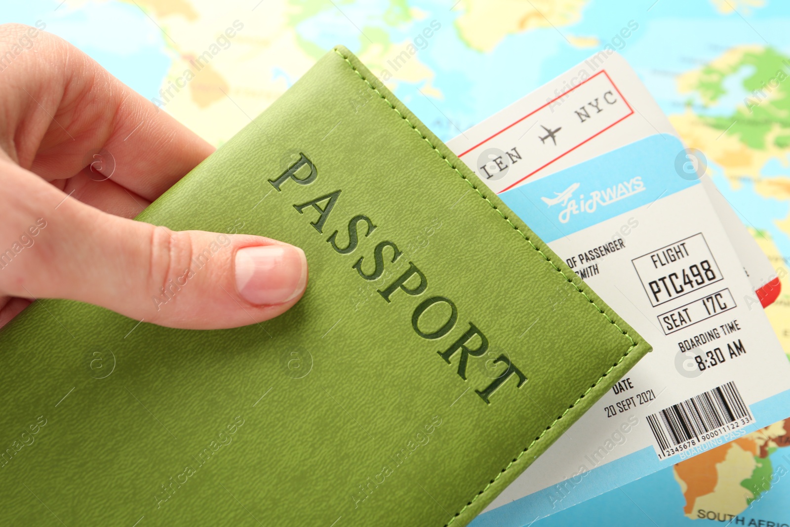 Photo of Person with passport and tickets on world map, closeup