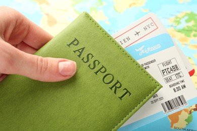 Photo of Person with passport and tickets on world map, closeup