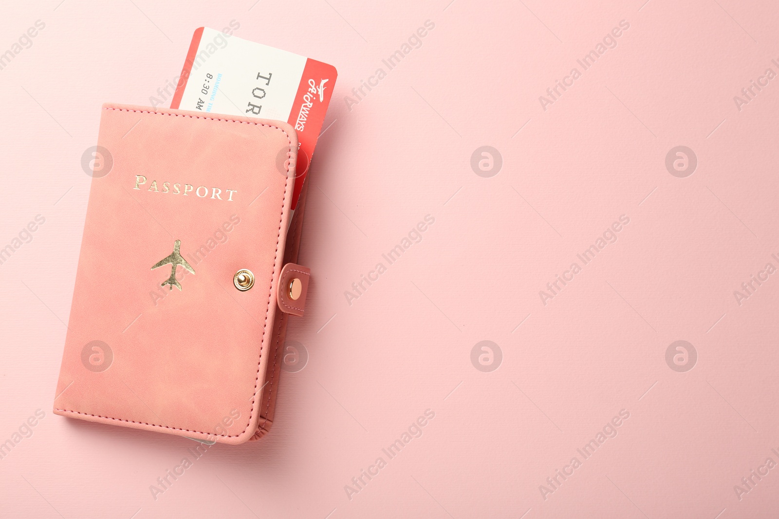 Photo of Passport with ticket on pink background, top view. Space for text