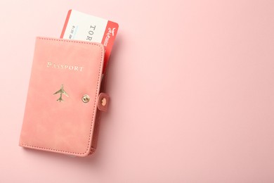 Photo of Passport with ticket on pink background, top view. Space for text