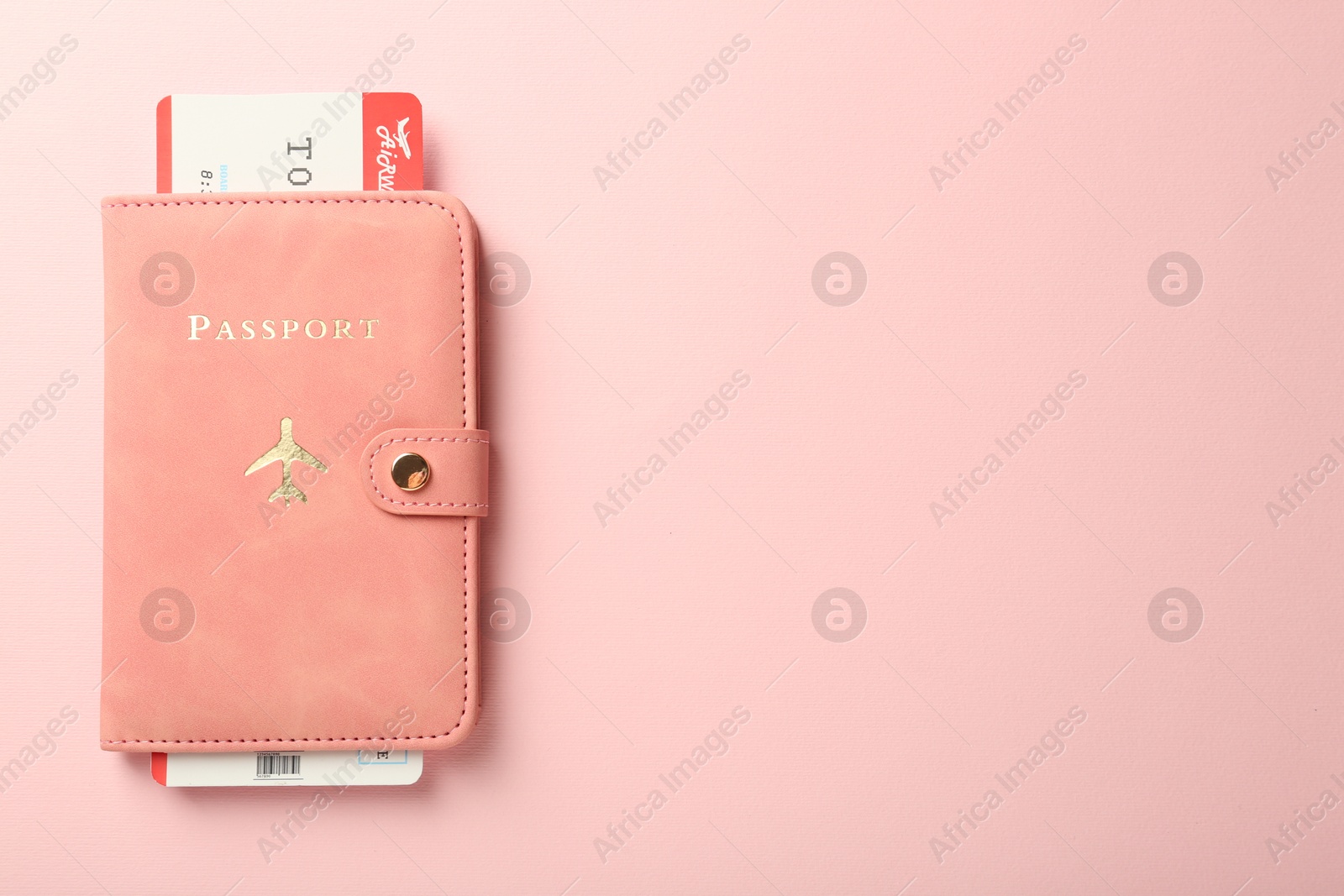 Photo of Passport with ticket on pink background, top view. Space for text