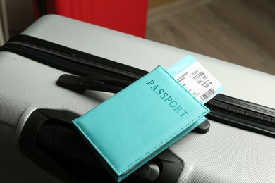 Photo of Passport with ticket on gray suitcase, closeup