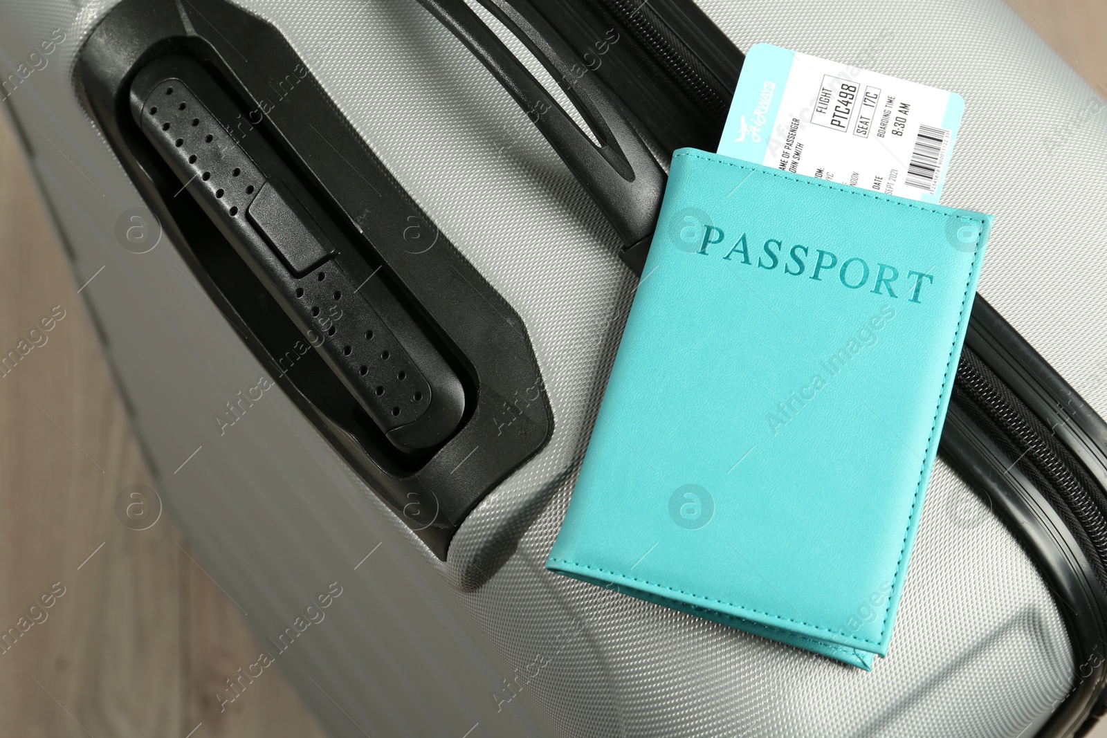 Photo of Passport with ticket on gray suitcase, closeup