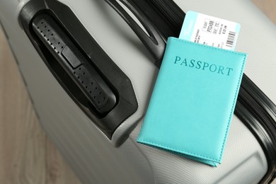 Photo of Passport with ticket on gray suitcase, closeup