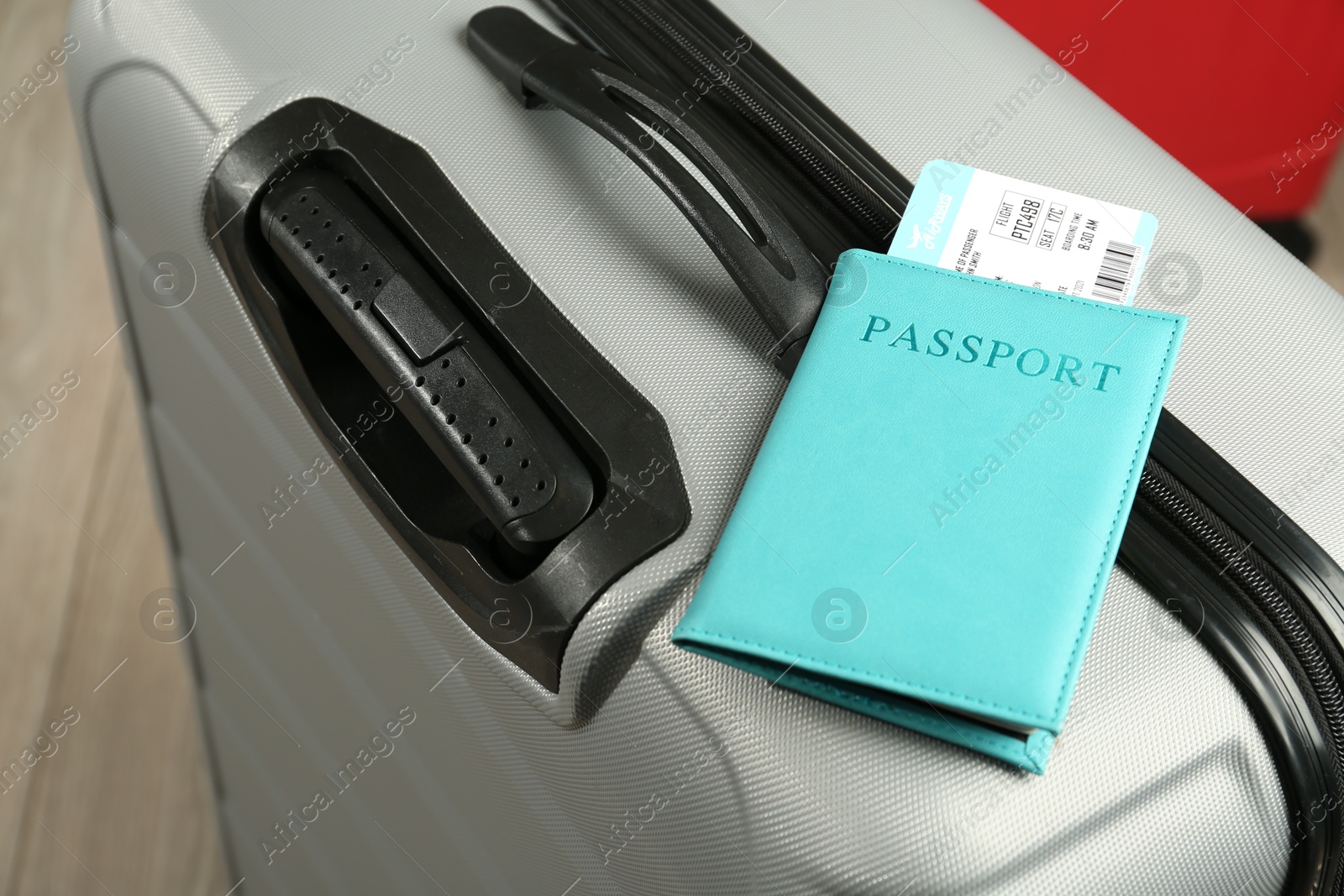 Photo of Passport with ticket on gray suitcase, closeup