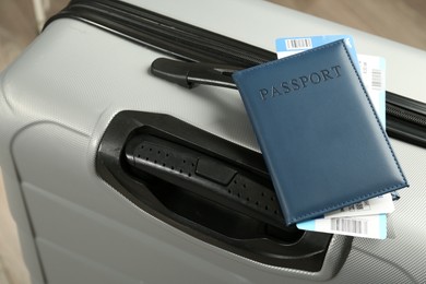 Photo of Passport with tickets on gray suitcase, closeup