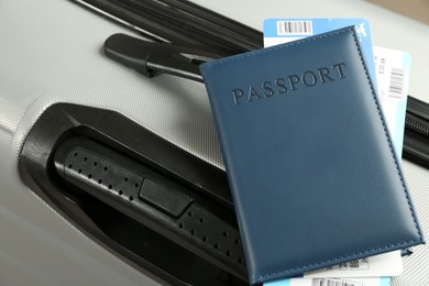 Photo of Passport with tickets on gray suitcase, closeup